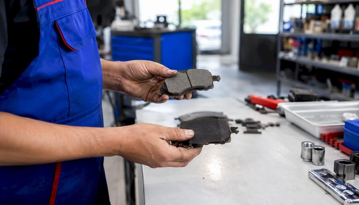 Mechanic comparing two types of brake pads