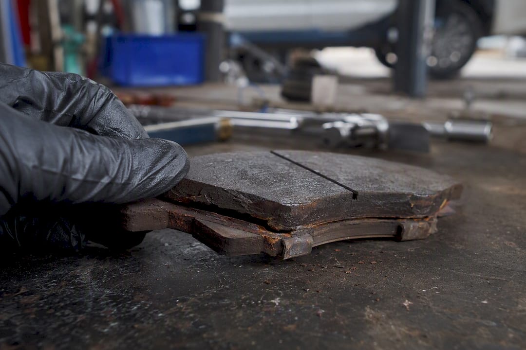 Close-up of brake pad with rust delamination