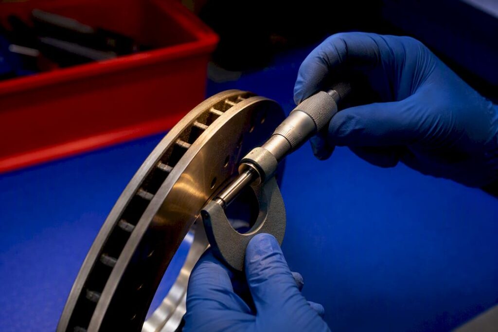 Technician measuring brake rotor thickness
