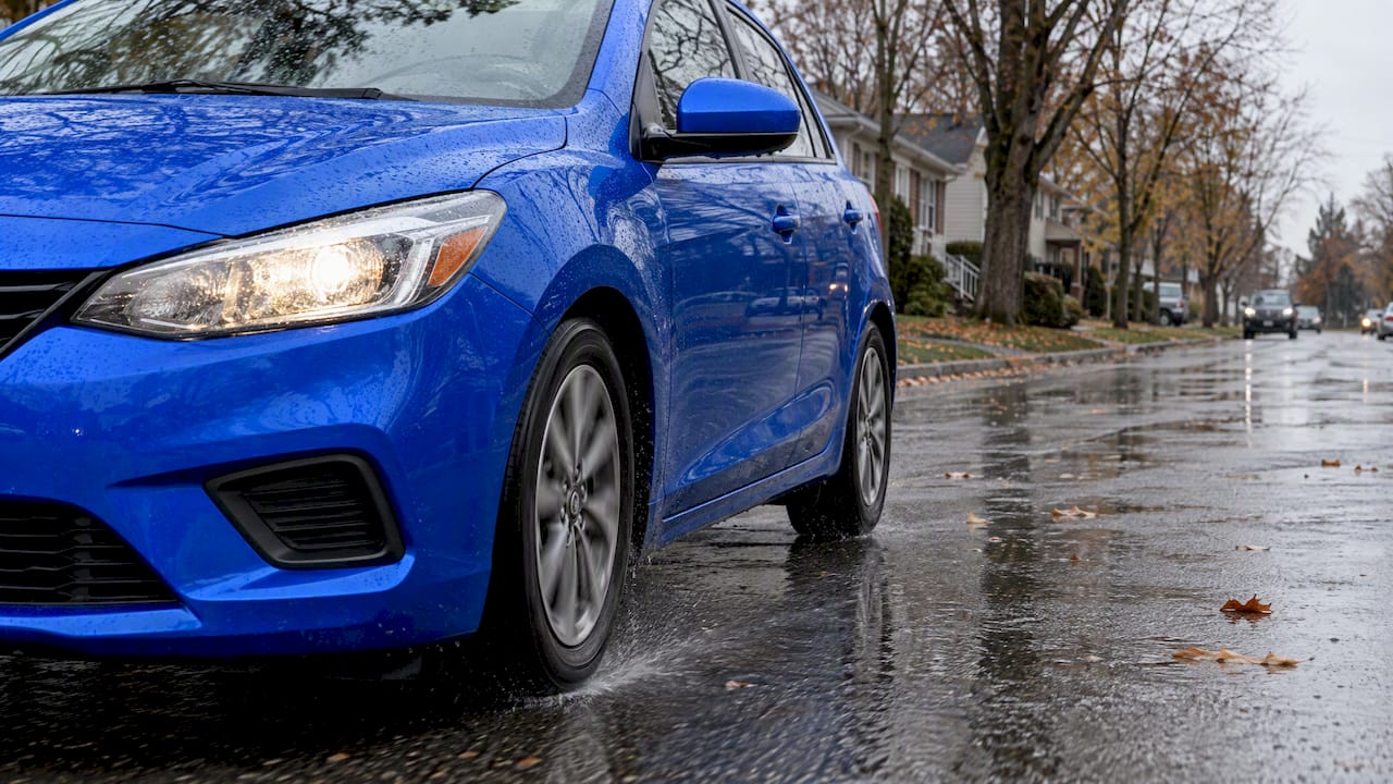 Blue car braking on a wet street